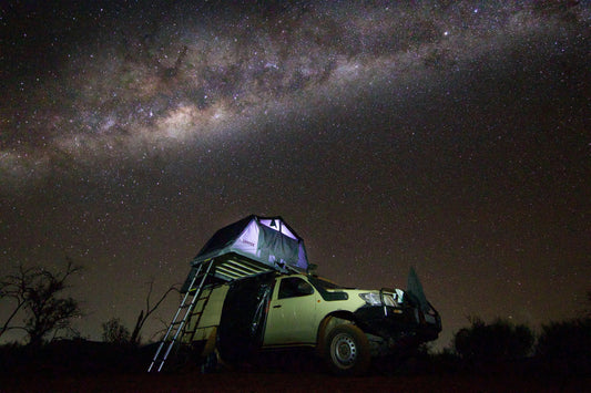 Car with rooftop tent under Australian night sky